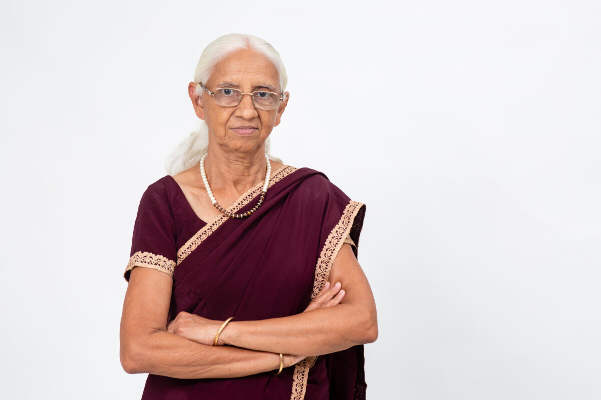 Senior woman in traditional attire, symbolizing women empowerment and community engagement in social justice activism.