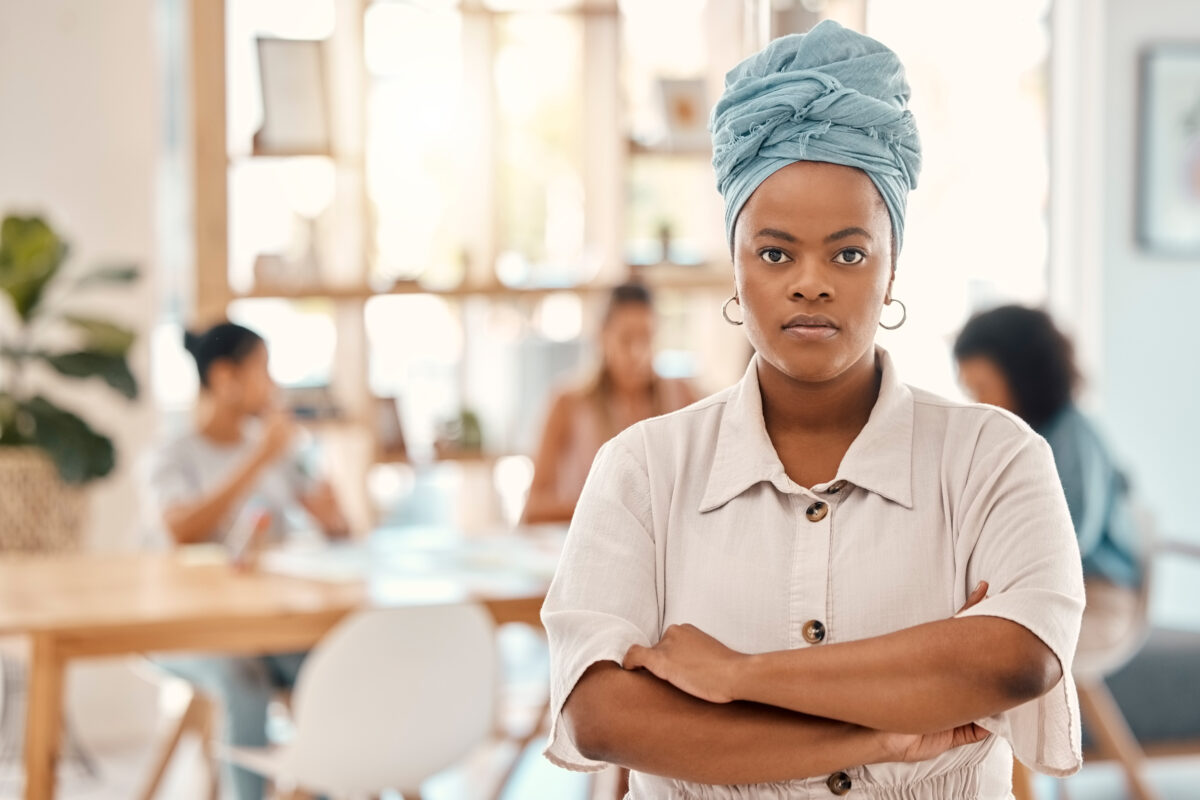 Women empowerment and activism in focus, featuring a confident woman of color in a community setting.