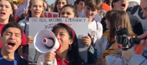 Young activists rally for social justice, holding signs and using megaphones, promoting community engagement and empowerment.