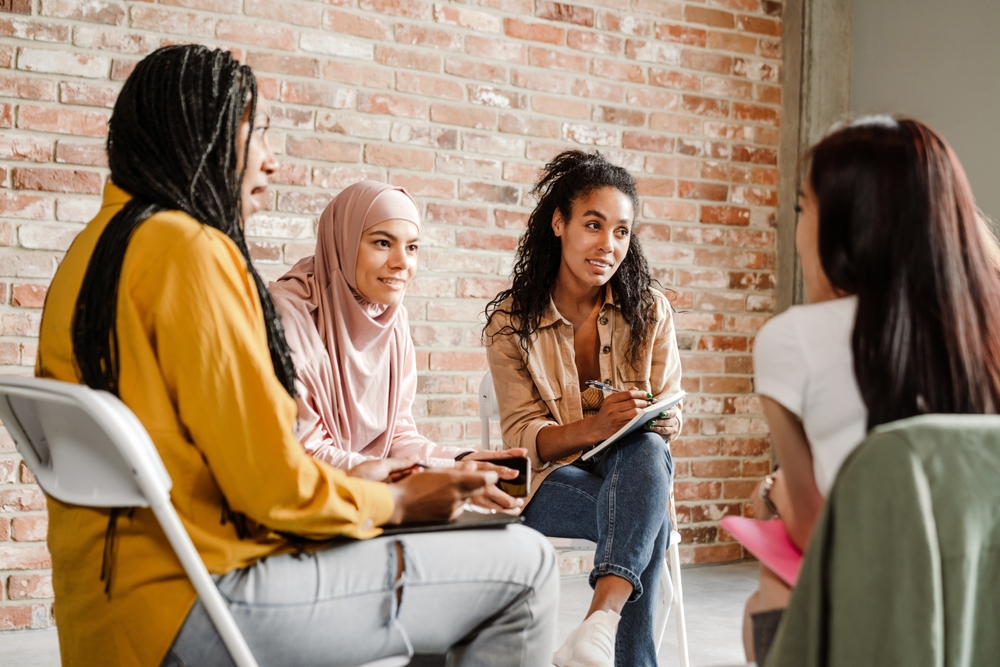 Multiracial,Young,Women,Discussing,Project,During,Meeting,Indoors